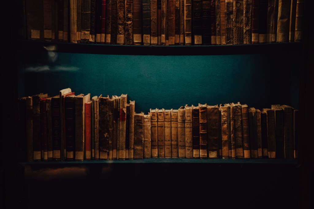 close up of worn books lined up on shelves